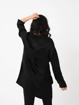 Camisa amplia color blanco, de textura arrugada, con laterales abiertos y detalle de tabla en la espalda.