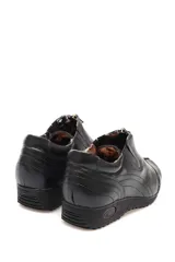 Bota de cuero color negro, estilo botín, con detalle de cierre en la capellada.