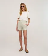 Short sastre de cintura alta con rayas verticales en tonos verde claro y blanco, confeccionado en sarga de algodón con trabillas y lazo ajustable en la cintura.