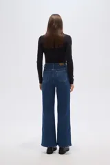 Pantalón jean negro de corte ancho y tiro alto, con cierre de botón y cremallera.