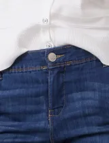 Jean de corte recto y tiro medio, confeccionado en denim elastizado de color azul oscuro. Presenta pretina con pasadores, cierre frontal con botón, bolsillos delanteros de entrada diagonal y bolsillos traseros tipo ojal.