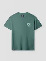 Camiseta de manga corta color verde azulado, corte holgado, con un pequeño estampado cuadrado con una 'X' en el pecho.