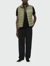 Chaleco acolchado marca Boss, modelo H-Cenito, en color verde militar. Presenta un diseño con costuras horizontales, cuello alto, cierre frontal completo y bolsillos laterales. Incluye el logotipo de la marca estampado en el pecho.