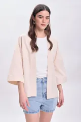 Kimono color crudo con bordado floral en la espalda, cuello mao y mangas 3/4 amplias.