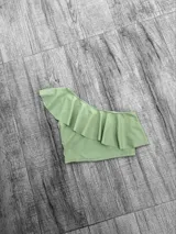 Top corto con un solo hombro y volado grande.