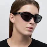 Gafas de sol negras con montura cat-eye oversized, lentes polarizadas con protección UV400, recubrimiento anti-scratch y superhydrophobic. Fabricadas con material bio-based G850 y patillas de propionato de celulosa.