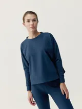 Sudadera deportiva de corte holgado con cuello redondo, mangas largas y aberturas laterales. Confeccionada en tejido técnico suave y elástico.