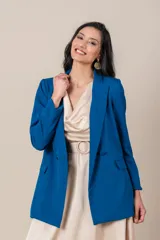 Blazer azul eléctrico de crepe y spandex, corte clásico, con solapas de muesca, cierre cruzado con botones forrados y bolsillos con solapa.