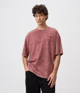 Remera masculina oversized de algodón con acabado desteñido y lavado desgastado de estilo vintage. Presenta cuello redondo de canalé y un pequeño bordado en el pecho con relieve.