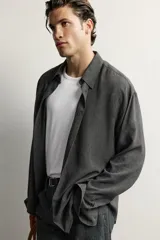 Camisa de hombre regular fit confeccionada en tejido fluido de viscosa gris, con cuello solapa, manga larga con puño abotonado y cierre frontal con botones.