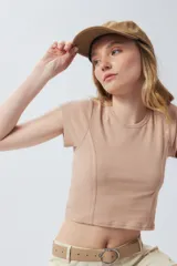 Top corto de manga corta, color negro con efecto desgastado o acid wash, cuello redondo y costuras verticales que definen la silueta.