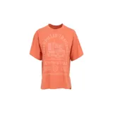 Remera de manga corta color naranja, con cuello redondo y corte boxy. Presenta un estampado gráfico en el pecho con el logo y maquinaria de Caterpillar.