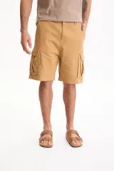 Bermuda cargo de gabardina color tostado, con bolsillos laterales con solapa y cierre frontal con botón y cremallera.