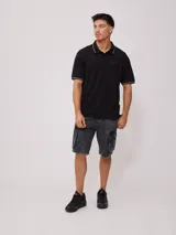 Remera polo blanca de corte regular, con cuello y mangas con ribete a cuadros en contraste. Presenta un pequeño logo bordado en el pecho.