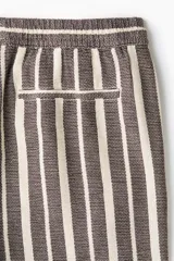 Short de corte regular fit en tejido texturizado con mezcla de algodón, con diseño de rayas verticales en tonos marrón y crudo. Cuenta con cintura elástica ajustable con cordón y bolsillos laterales.