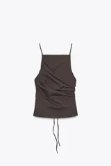 Top marrón con escote recto y tirantes finos. Presenta detalle de pliegues en el frente y espalda descubierta con cierre de lazadas.