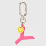 Llavero con dije en forma de letra A color rosado y pequeño dije circular amarillo con logo de la marca grabado. Incluye gancho metálico tipo mosquetón.