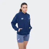 Canguro Umbro azul marino del Club Nacional de Football con capucha, cordones de ajuste, bolsillo tipo canguro y costuras decorativas visibles en contraste. Presenta el logo de Umbro y el escudo del club bordados en el pecho.