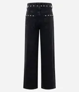 Pantalón wide leg de denim negro con acabado desgastado, tiro medio y aplicación de tachas metálicas a lo largo de los laterales.