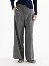 Pantalón de silueta wide leg confeccionado en mezcla de lana, con diseño de rayas verticales y sutiles lentejuelas bordadas. Presenta cierre frontal con gancho y botón interno, bolsillos laterales y bolsillo ojal en la parte posterior.