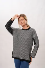 Sweater de punto con cuello redondo y mangas largas. Diseño a rayas verticales en tonos gris y negro.