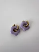 Aros de acero quirúrgico hipoalergénico con argolla dorada y dije colgante en forma de flor color violeta.