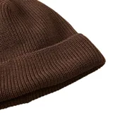 Gorro tipo beanie de tejido de punto acanalado en color marrón, con borde doblado y etiqueta pequeña con el logo de la marca en el frente.