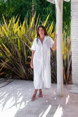 Vestido camisero de muselina color negro, de largo midi, con cuello clásico, manga corta y cierre frontal con botones.