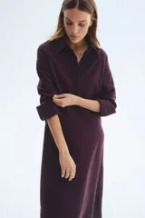 Vestido midi color bordó, con cuello camisero y tapeta con botones ocultos, de manga larga con puños anchos abotonados y corte holgado.