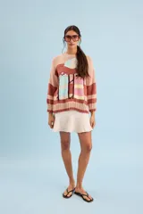 Buzo de algodón tejido a mano, de calce relajado y cuello redondo, con diseño gráfico inspirado en carpas de playa y franjas horizontales en tonos rosado, marrón, celeste y amarillo.