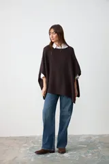 Poncho de tejido de punto con textura en color marrón oscuro, de corte holgado y diseño sin mangas.