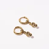 Aros dorados tipo argolla con dije colgante con forma de nudo.