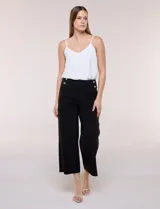 Pantalón crop blanco de corte recto con cintura ancha y botones decorativos laterales. Cuenta con bolsillos y pinzas frontales.