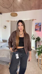 Camisa marrón con cuello camisero, cierre frontal con botones, mangas largas y bolsillos plaqué con solapa en el pecho.