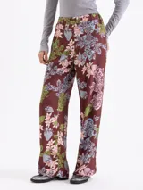 Pantalón de corte recto y holgado, con estampado floral y de fresas sobre fondo color marrón. Presenta cintura elástica y diseño fluido.