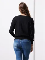 Cárdigan negro tejido en hilado fino con escote en V y un botón.