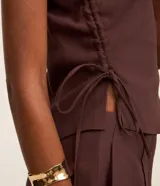 Blusa sastre de un solo hombro con tirante ancho, bajo asimétrico y detalle de tiras ajustables con regulador en el lateral.