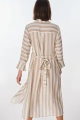 Vestido camisero largo a rayas horizontales verdes y blancas, con cuello clásico, mangas 3/4 y abertura frontal con botones. Confeccionado en lino.