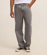 Pantalon de jean gris con lavado deslavado, de corte baggy y silueta holgada. Cuenta con bolsillos al frente y atras, y cierre de boton y cremallera.