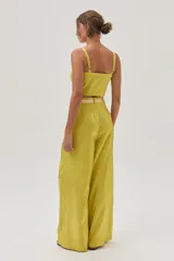 Pantalón sastrero de tiro alto color verde lima, confeccionado en tafeta metalizada, con calce holgado y pierna ancha.