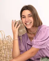 Billetera de cuero color visón con diseño acolchado de costuras cuadradas y cierre metálico perimetral.