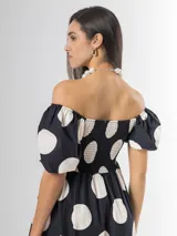 Vestido largo de lunares con escote bote y hombros descubiertos, mangas cortas abullonadas, cuerpo con nido de abeja y falda amplia.