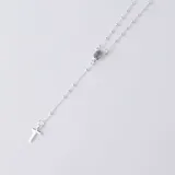 Rosario de plata 925 con cadena de eslabones finos y pequeñas cuentas esféricas intercaladas. Presenta una medalla central con imagen religiosa y un dije de cruz en el extremo.