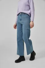 Pantalón de jean azul claro, de corte ancho y tiro alto, con ruedo deshilachado.