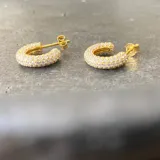 Aros tipo argolla pequeños, dorados, con incrustaciones de circonitas blancas.