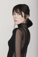 Camiseta negra de cuello alto y mangas largas con paneles de tul transparente en mangas y espalda.