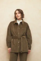 Sobrecamisa de pana color beige, con cuello camisero, cierre frontal con botones metálicos, mangas largas con puños abotonados y lazo ajustable en la cintura.