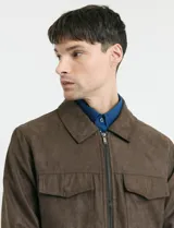 Campera Harrington de gamuza en color marrón, con cierre frontal, cuello clásico y bolsillos laterales con solapa.