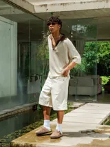 Chomba de tejido de punto abierto color crudo con cuello polo en color marrón chocolate.