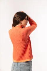 Sweater de punto acanalado color coral, con cuello alto y mangas largas con puños acampanados.